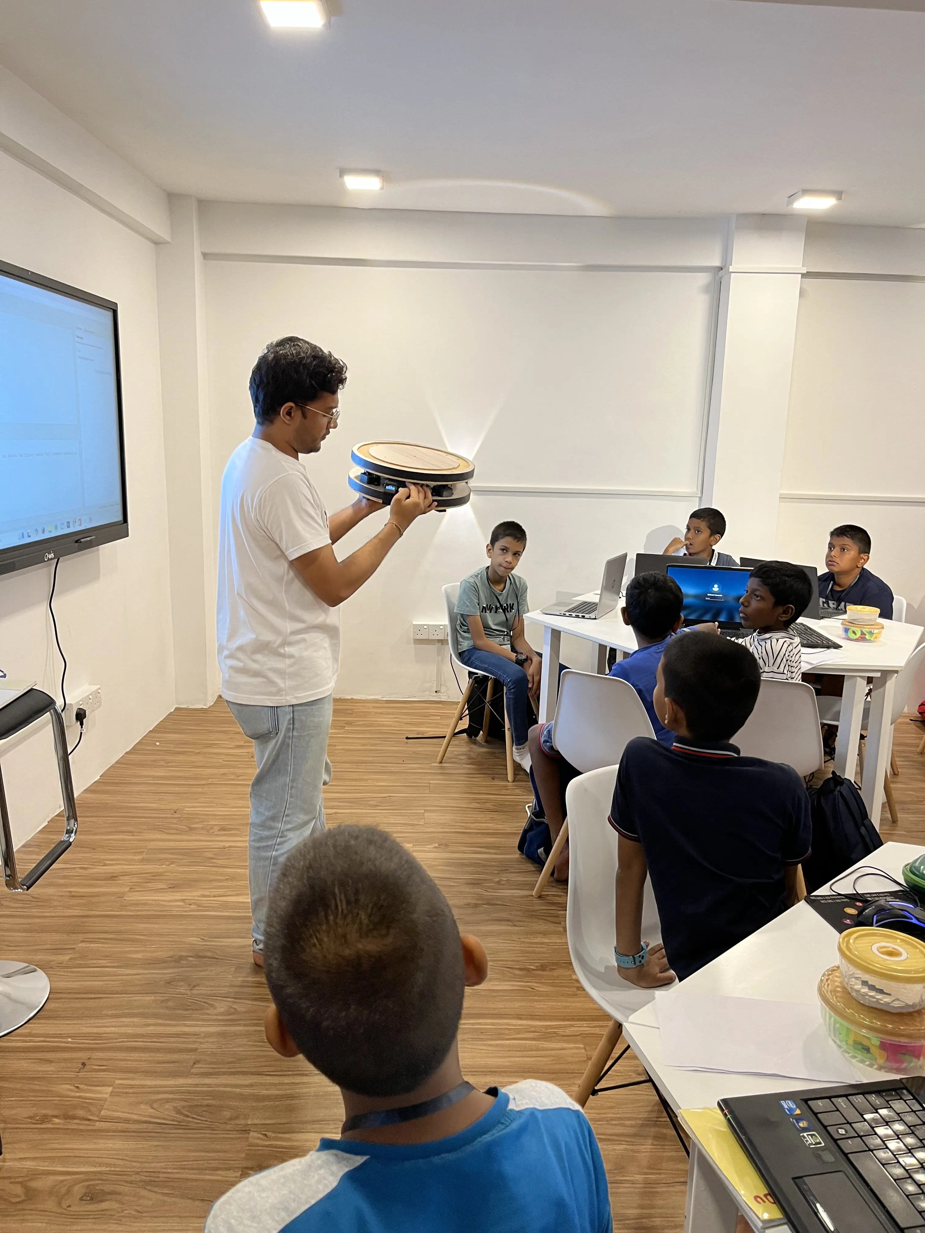 Young learners engaged in a practical robotics demonstration.